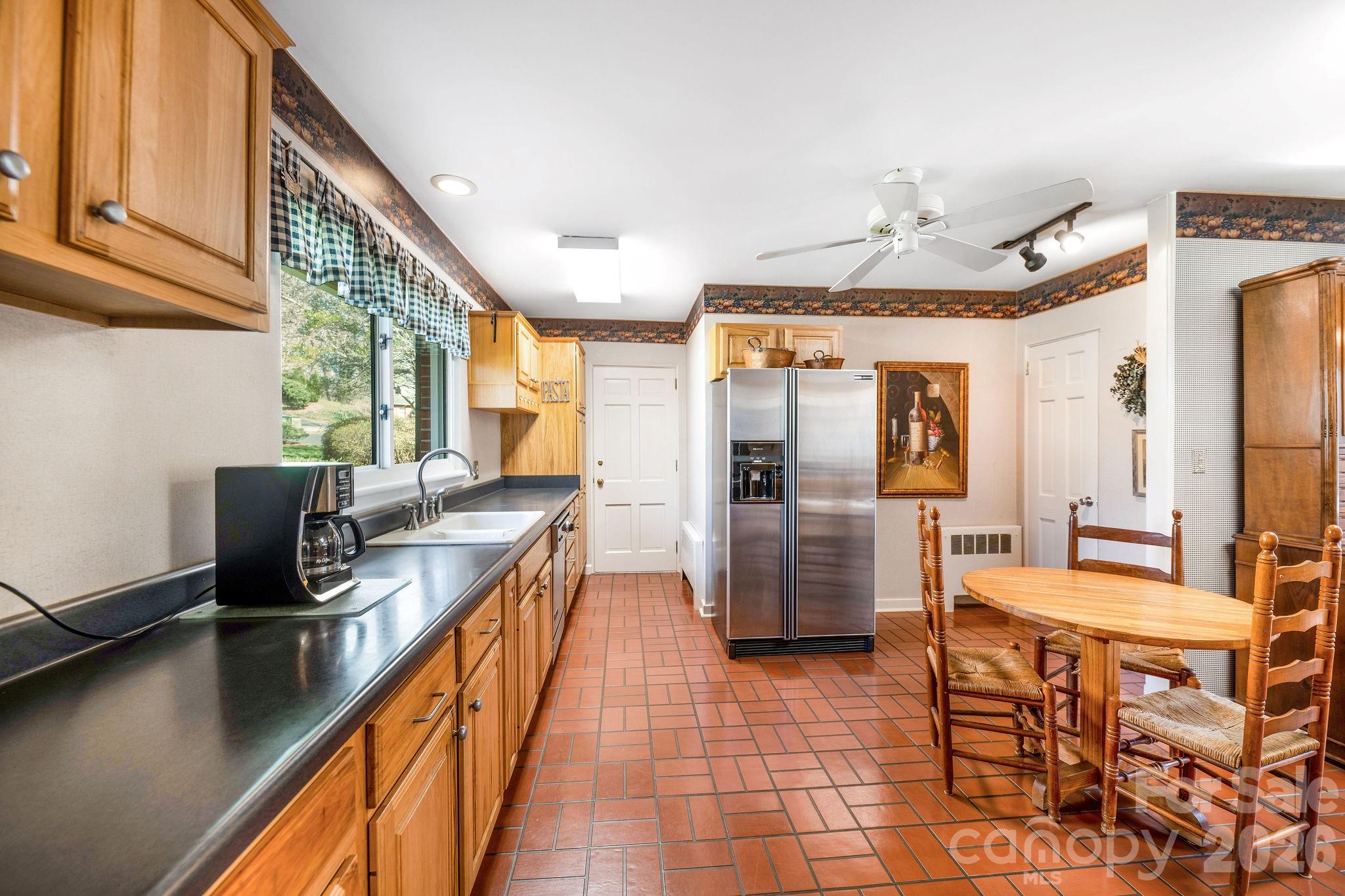 4 Dogwood Road Asheville, NC 28804 - Photo 19 of 48 a kitchen with stainless steel appliances granite countertop a refrigerator a sink dishwasher a stove and a dining table with wooden floor