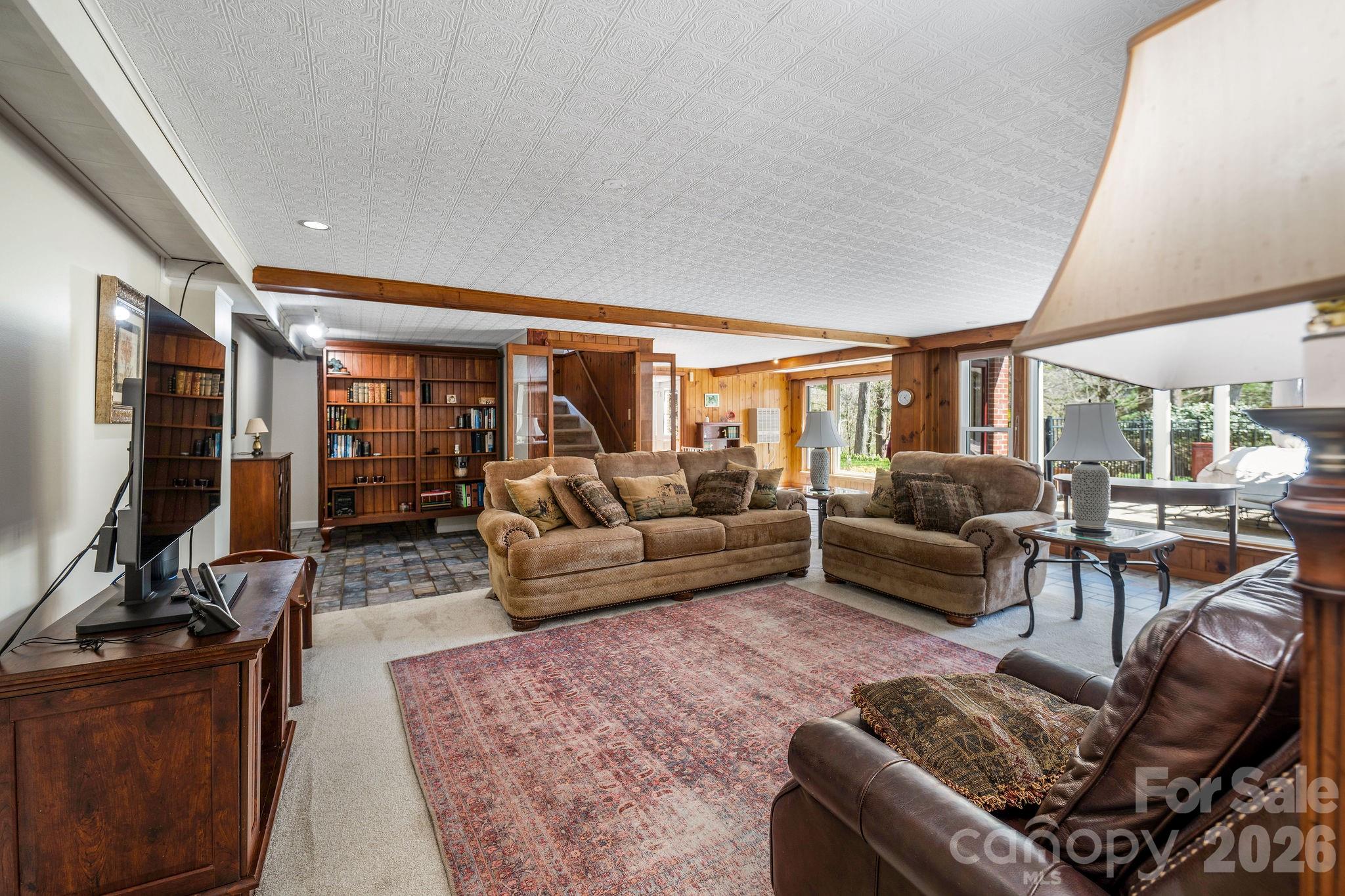4 Dogwood Road Asheville, NC 28804 - Photo 37 of 48 a living room with furniture a flat screen tv and a floor to ceiling window