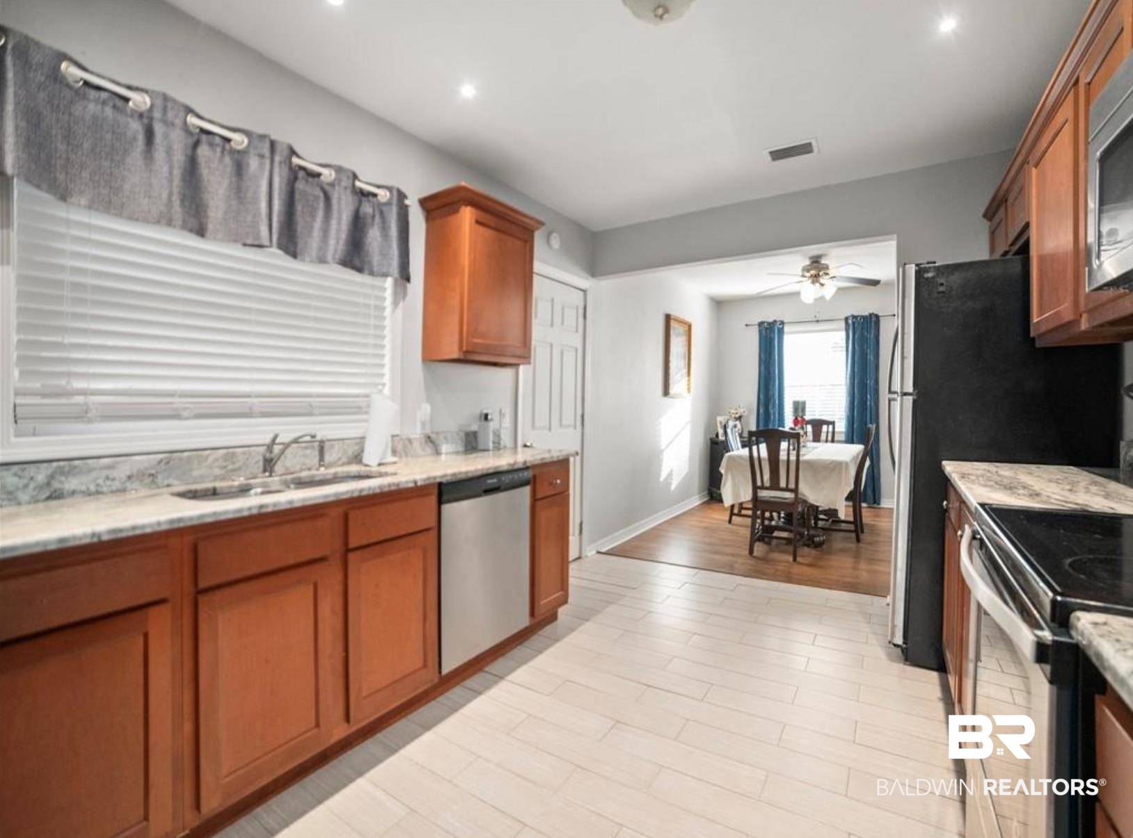 1420 Vega Drive Mobile, AL 36693 - Photo 5 of 18 Kitchen with stainless steel appliances, brown cabinetry, light wood-style floors, light stone counters, and recessed lighting