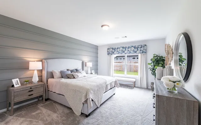 a bedroom with a bed a large window with table and chairs