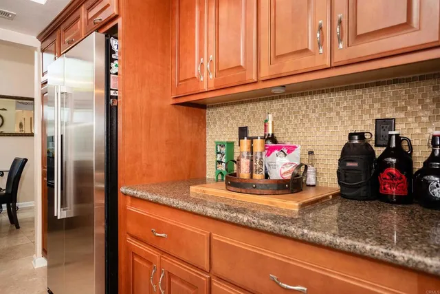 a kitchen view with granite countertop a refrigerator and a sink