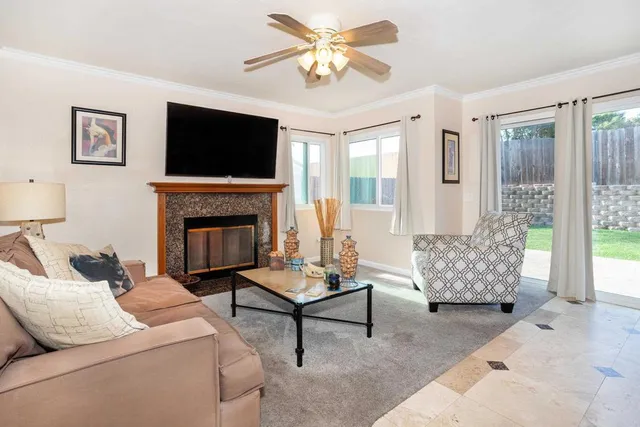 a living room with furniture a flat screen tv and a fireplace
