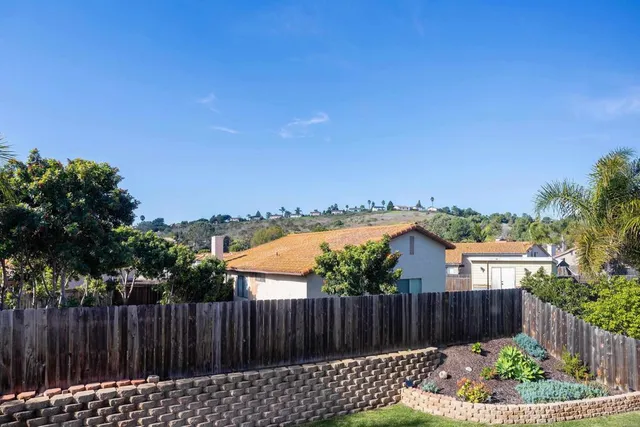 a view of a backyard with wooden fence
