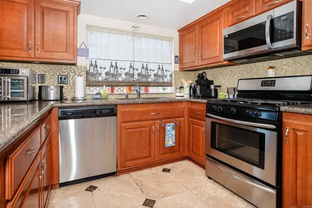 a kitchen with stainless steel appliances granite countertop a stove top oven microwave and cabinets