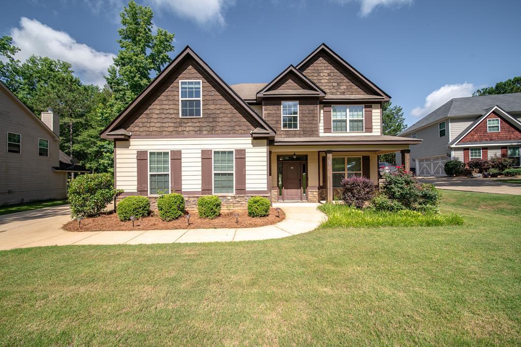 a front view of a house with yard and green space