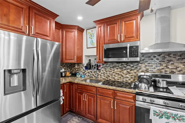 a kitchen with stainless steel appliances granite countertop a refrigerator and a sink