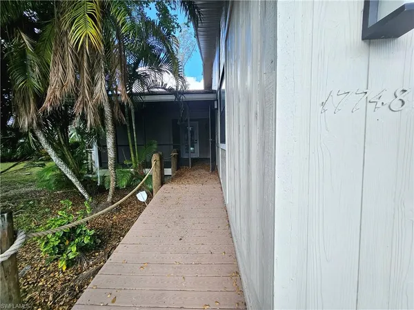 a view of a entryway door with flower pots