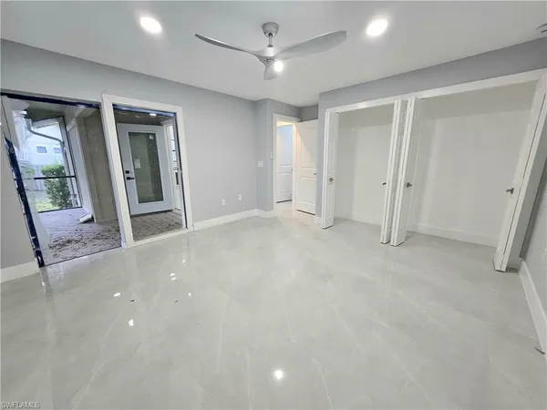 en empty room with windows and ceiling fan