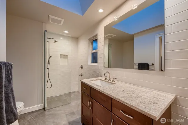 a bathroom with a granite countertop sink and a mirror