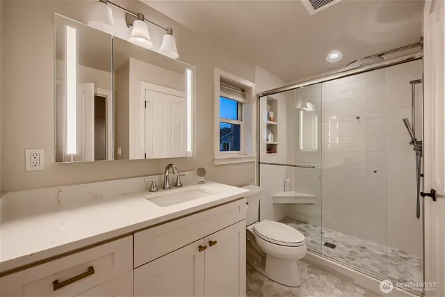 a bathroom with a sink a toilet and shower