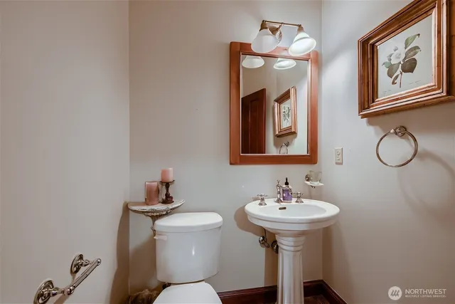 a bathroom with a toilet a sink and mirror