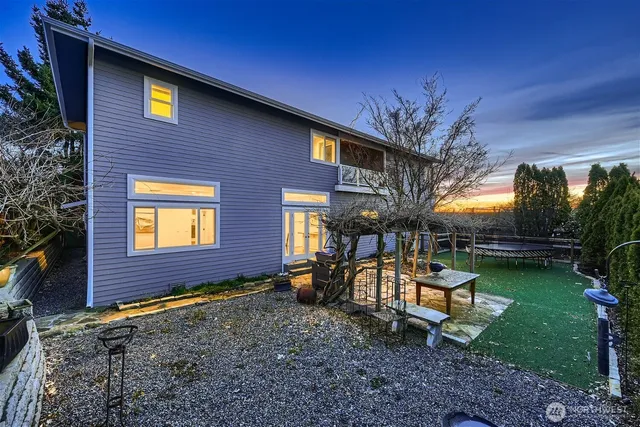 a view of a brick house with a yard table and chairs