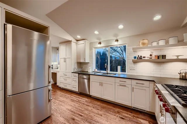 a large kitchen with stainless steel appliances granite countertop a refrigerator and a stove top oven