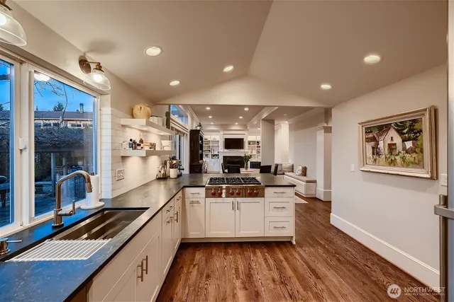 a kitchen with kitchen island a counter top space a sink stainless steel appliances and cabinets