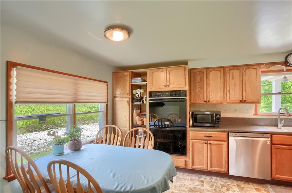 119 Lovi Road Baden, PA 15005 - Photo 8 of 41 a kitchen with stainless steel appliances granite countertop a stove a refrigerator a sink a dining table and chairs with wooden floor