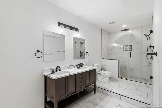 a bathroom with a sink mirror and toilet
