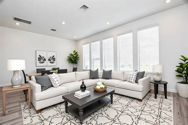 a living room with furniture potted plant and a large window
