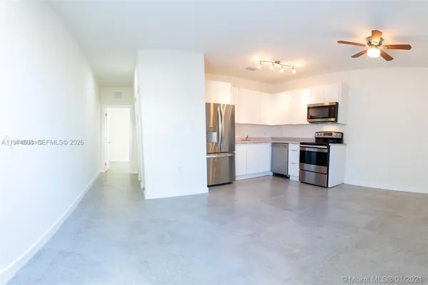 a view of a kitchen with a sink and a refrigerator