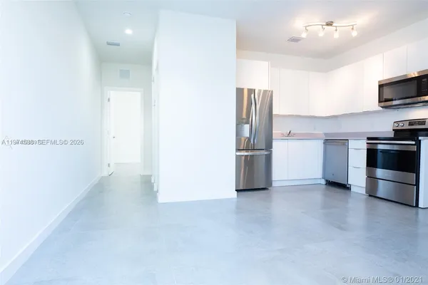 a view of a kitchen with a refrigerator a microwave and a sink