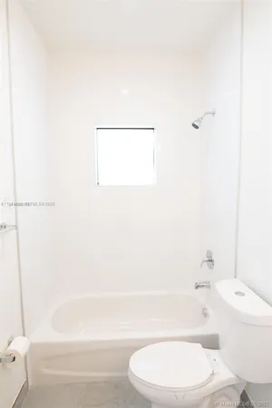 a bathroom with a white bath tub a toilet and a sink