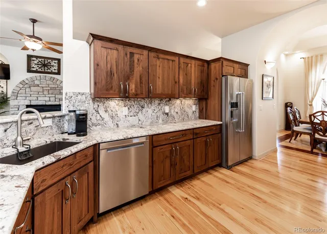 a kitchen with stainless steel appliances granite countertop wooden cabinets a stove top oven a sink and dishwasher