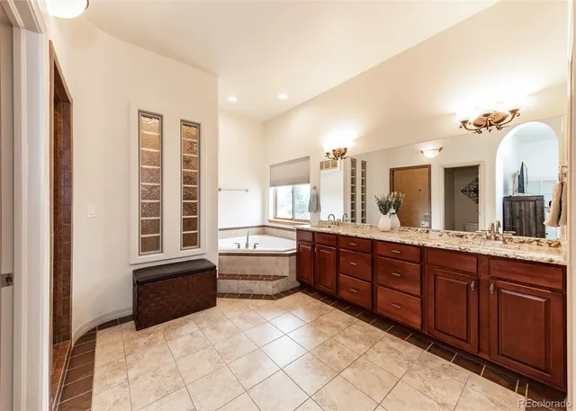 a large bathroom with a tub a sink and mirror