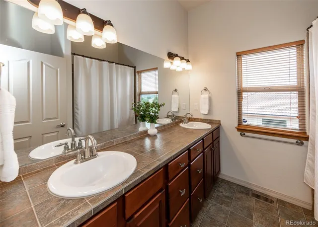 a bathroom with a granite countertop sink and a mirror