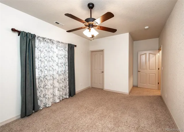 an empty room with fan and closet