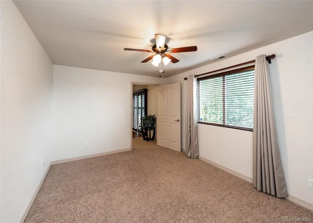 a view of a livingroom with a ceiling fan and window