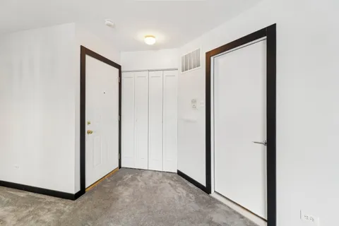 an empty room with windows and closet