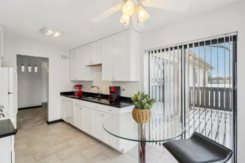 a kitchen with granite countertop a stove a sink and a refrigerator