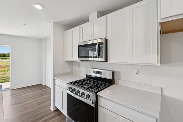 a kitchen with granite countertop a stove and a microwave
