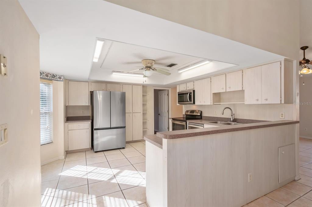 10795 Southwest 53rd Circle Ocala, FL 34476 - Photo 16 of 47 a kitchen with stainless steel appliances granite countertop a sink and a refrigerator