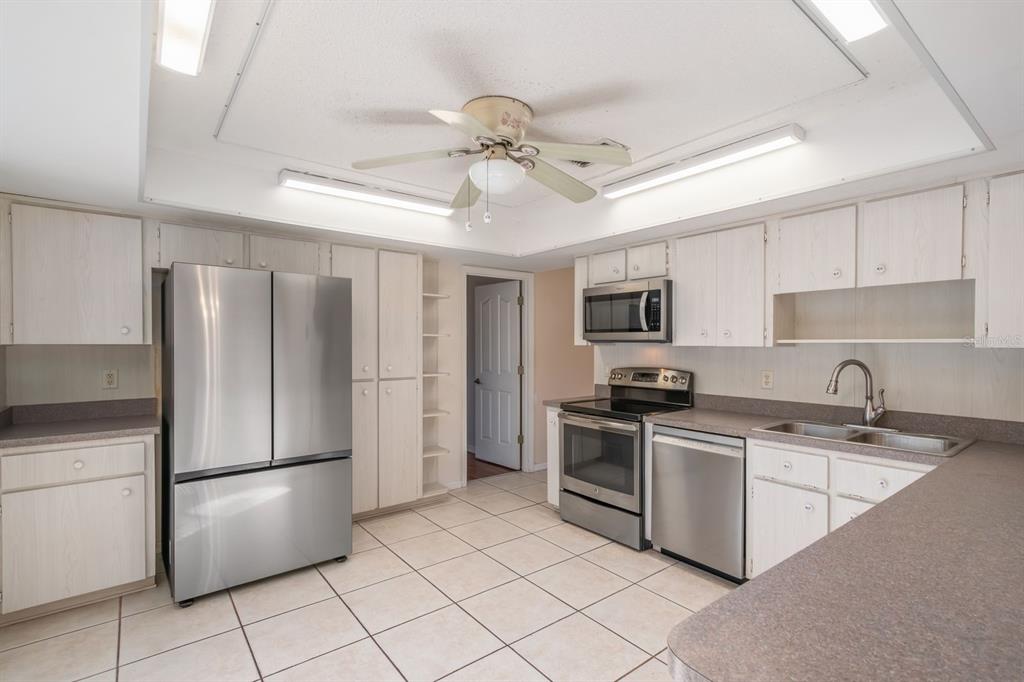 10795 Southwest 53rd Circle Ocala, FL 34476 - Photo 17 of 47 a kitchen with stainless steel appliances granite countertop a refrigerator a stove a sink and a microwave