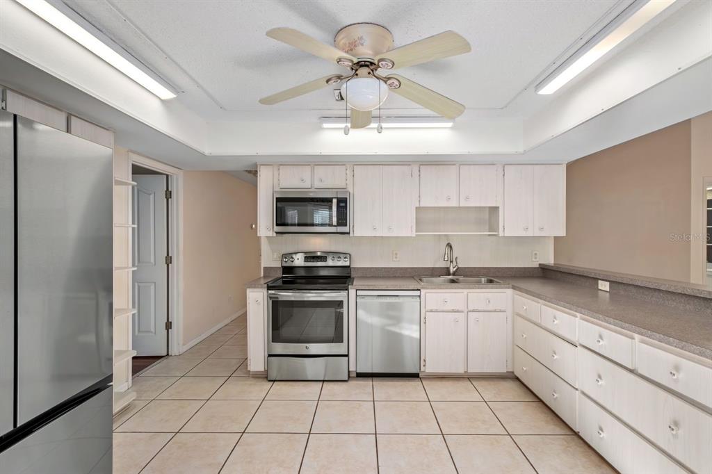 10795 Southwest 53rd Circle Ocala, FL 34476 - Photo 18 of 47 a kitchen with stainless steel appliances granite countertop a stove a sink and a refrigerator