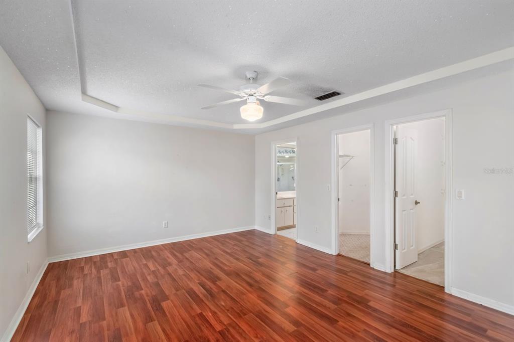 10795 Southwest 53rd Circle Ocala, FL 34476 - Photo 22 of 47 a view of a room with wooden floor and a ceiling fan