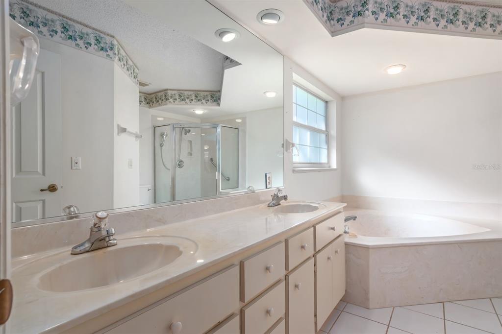 10795 Southwest 53rd Circle Ocala, FL 34476 - Photo 25 of 47 a bathroom with a sink double vanity granite tub and a mirror