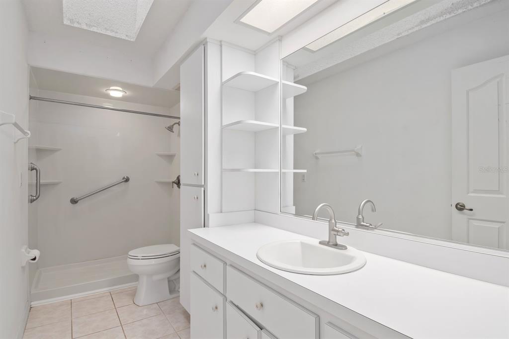 10795 Southwest 53rd Circle Ocala, FL 34476 - Photo 34 of 47 a bathroom with a granite countertop sink toilet a mirror and shower