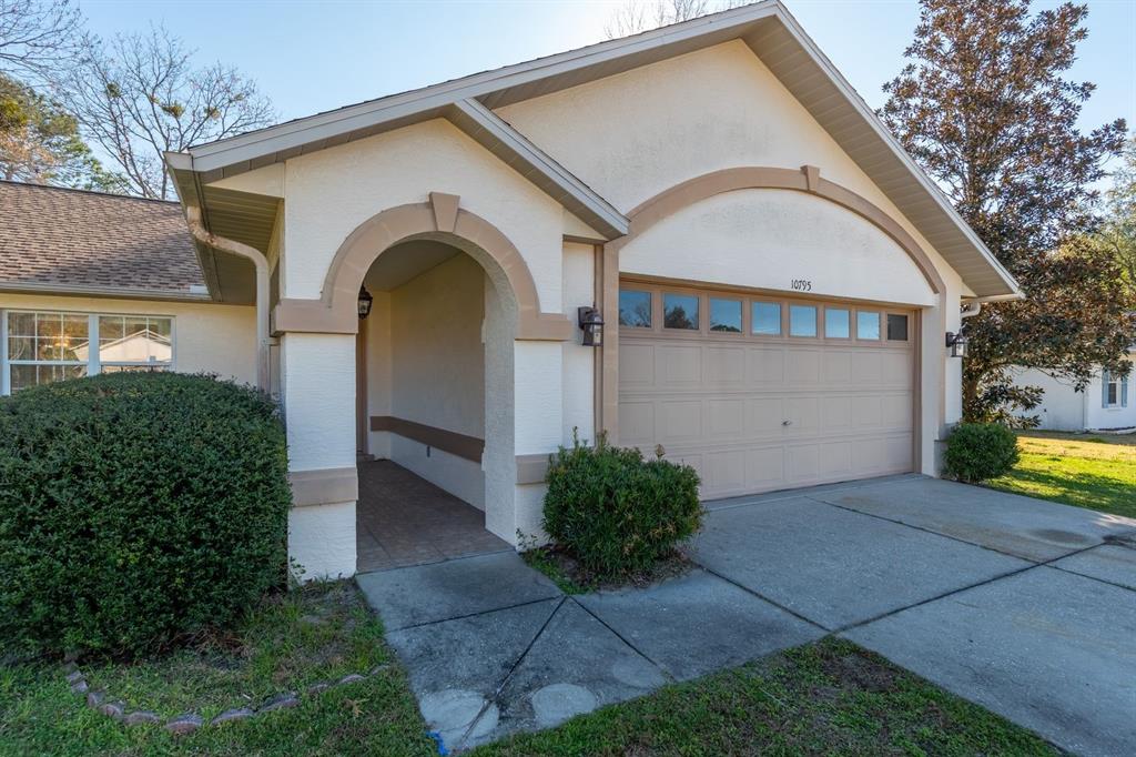 10795 Southwest 53rd Circle Ocala, FL 34476 - Photo 7 of 47 a view of a grey house with a yard and plants
