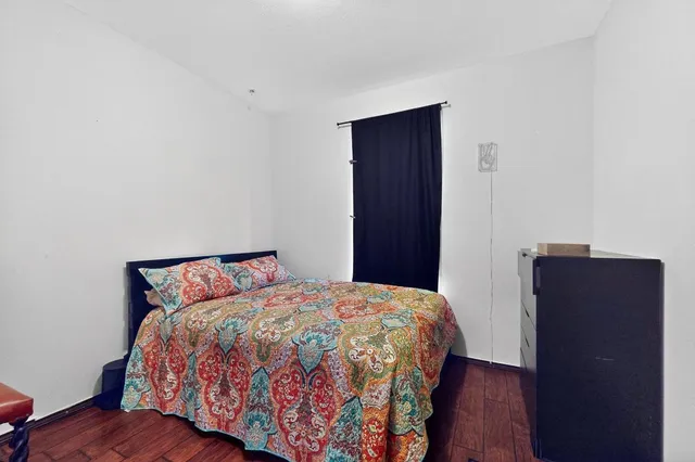 a bedroom with a large bed and wooden floor