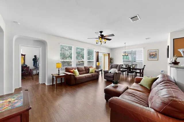 a living room with furniture kitchen view and a chandelier