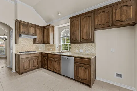 a large kitchen with stainless steel appliances kitchen island granite countertop a large counter top and a stove