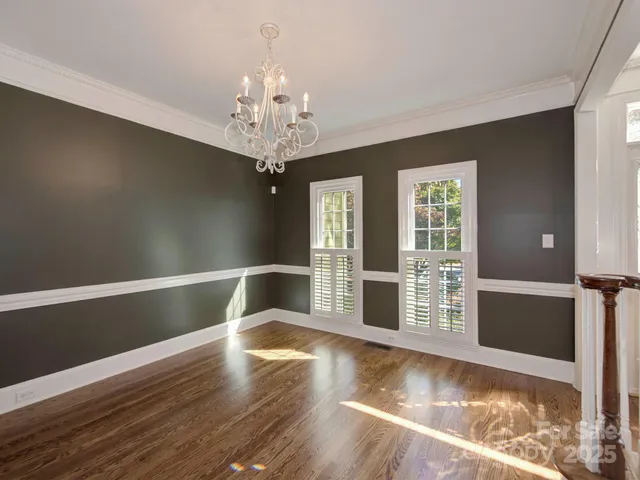 a view of a livingroom with wooden floor and kitchen