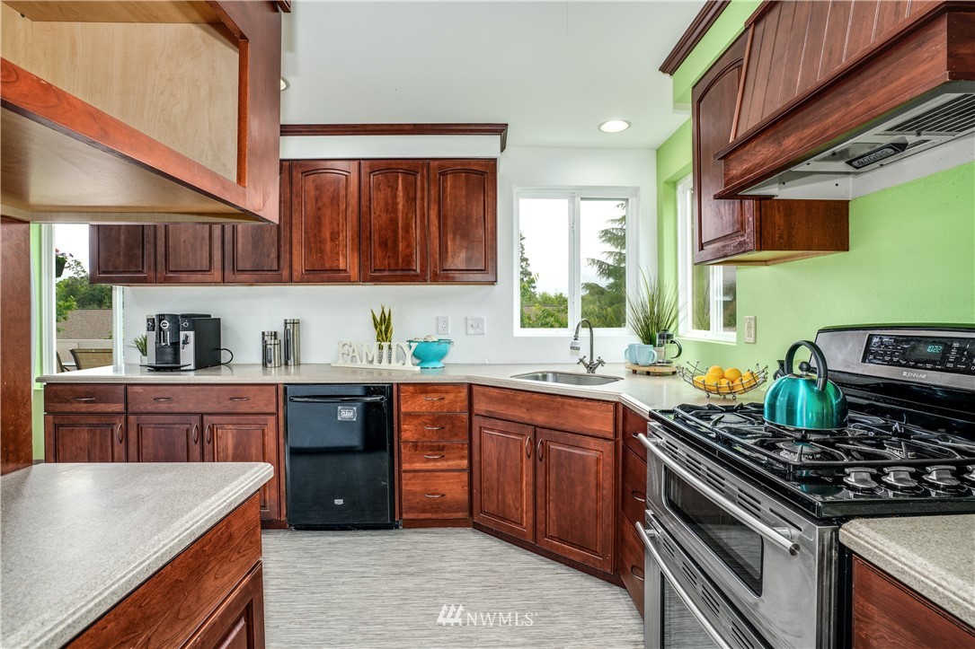 527 224 Place Southeast Bothell, WA 98021 - Photo 4 of 23 a kitchen with stainless steel appliances granite countertop a stove a sink dishwasher and cabinets