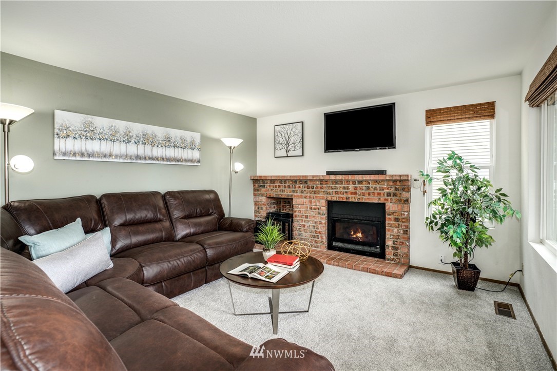 527 224 Place Southeast Bothell, WA 98021 - Photo 8 of 23 a living room with furniture a flat screen tv and a fireplace