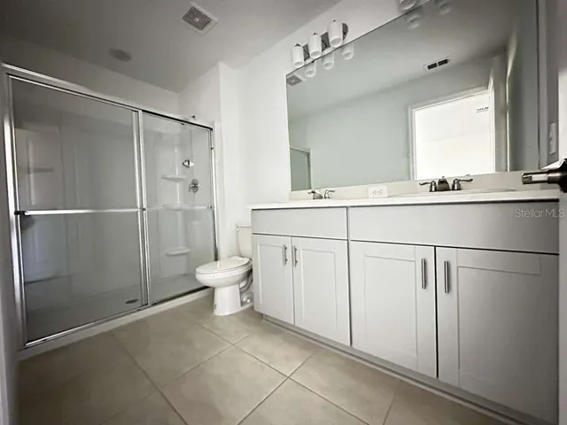 a bathroom with a shower sink and mirror
