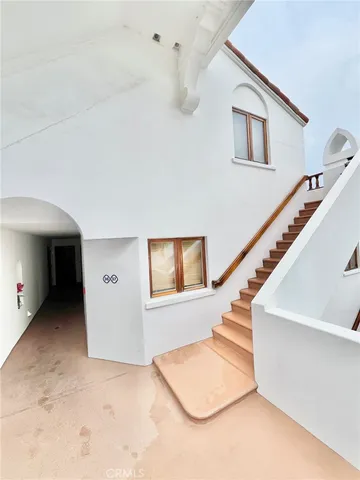 a view of a hallway with windows and stairs