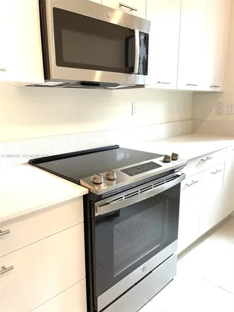 a kitchen with appliances a window and a counter top space