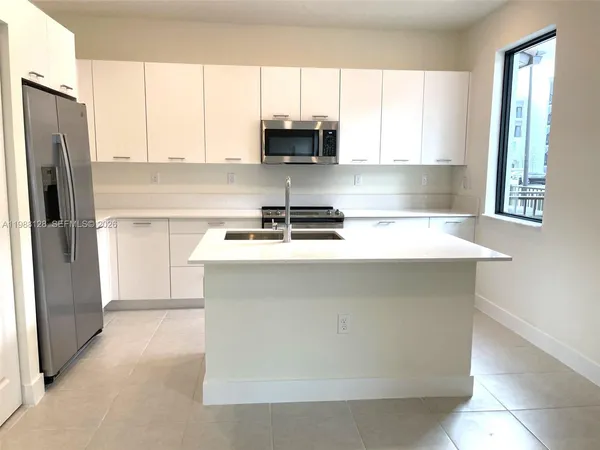 a view of a kitchen with an empty space and a window