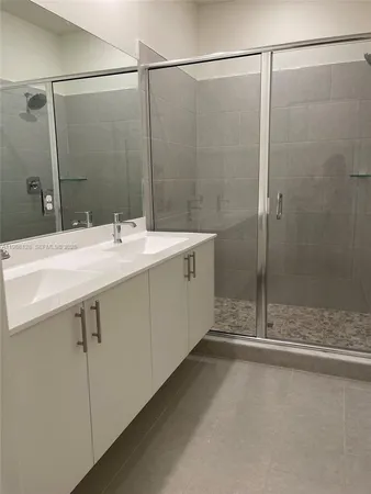 a bathroom with a double vanity sink and mirror